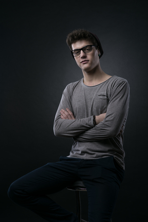 Smiling handsome nerd guy portrait on dark backgroundの写真素材