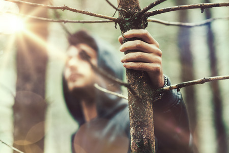 Hooded guy in the woods exploring nature, individuality and freedom conceptの写真素材