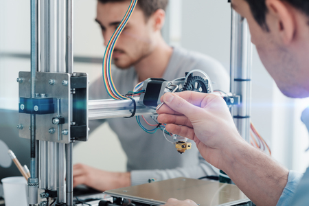 Engineering students using an innovative 3D printer in the laboratory