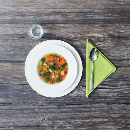 Tasty vegetable soup in a dish on a rustic wooden table, healthy eatingの写真素材