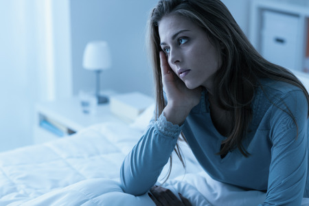 Depressed woman awake in the night, she is exhausted and suffering from insomniaの写真素材