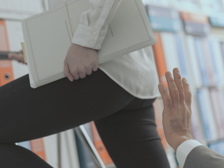Sexual harassment in the workplace: the boss is about to touch his female employee's buttocksの写真素材