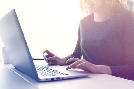 Woman doing online shopping using her laptop and a credit card, hands close up, e-commerce and online banking conceptの写真素材