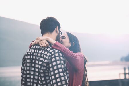 Romantic young couple at the lake, they are hugging and smiling, love and relationships conceptの写真素材