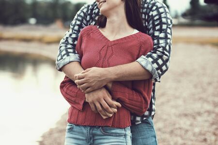 Happy young couple at the beach, they are hugging and enjoying together