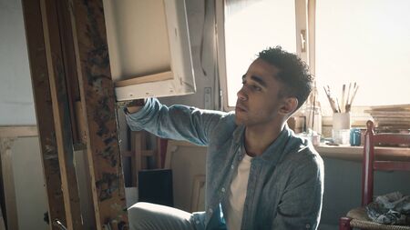 Young creative artist working in the studio, he is painting on canvas, art and talent conceptの写真素材