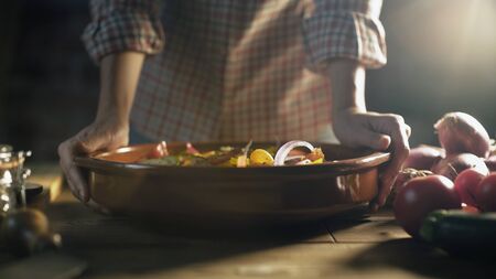 Woman cooking in the kitchen at home, she is preparing healthy fresh vegetables in a bowl