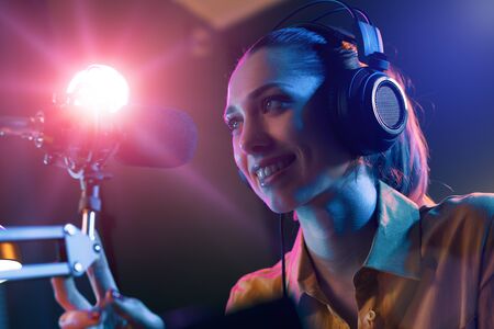 Young smiling host at the radio broadcasting station, communication and entertainment conceptの写真素材