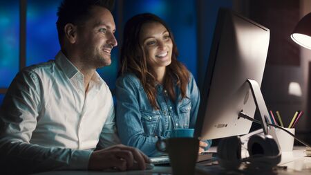 Happy couple connecting online together at home, they are watching videos and films late at night