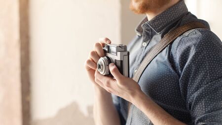 Hipster young man holding a vintage camera, 1960s styleの写真素材