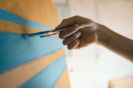 Artist creating an abstract artwork, he is painting on canvas with a brush, hand close upの写真素材