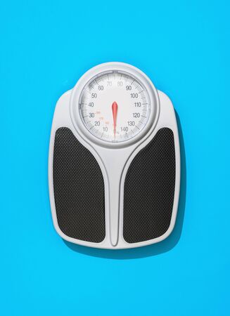 Analog weight scale on light blue background: fitness, diet and weight loss conceptの写真素材