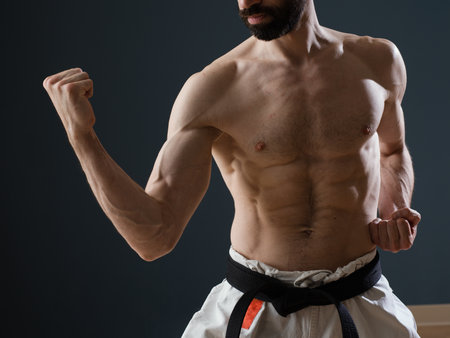 A Sensei karateka instructor trains alone in his dojo showing off an enviable musculatureの写真素材