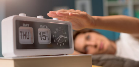 Woman lying down on the sofa at home, she wakes up and turns off the alarm