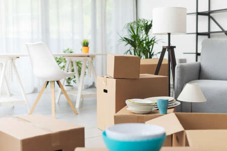 Home relocation and real estate: cardboard boxes and furniture in the new apartmentの写真素材