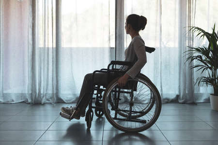 Woman in wheelchair at home alone, disability and loneliness conceptの写真素材
