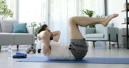 Man exercising at home and doing abs workout, fitness and sports concept
