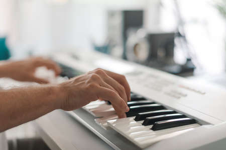 Professional musician playing a digital piano in his studio, creativity and arts conceptの写真素材