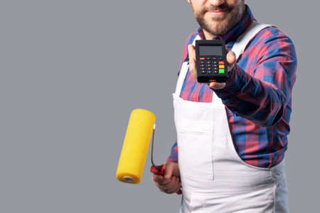 Home painter showing a POS terminal and a paint roller, professional service concept