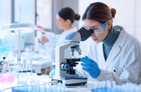 Young scientists conducting research investigations in a medical laboratory, a researcher in the...