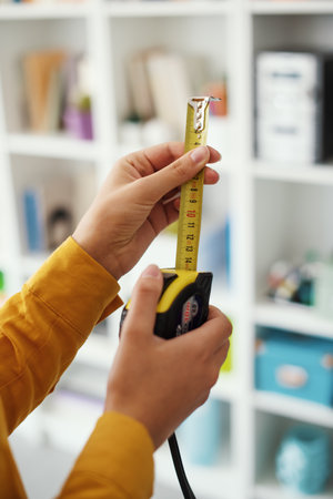 Woman holding a roll meter, she wants to maximize space in her home, DIY and interior design conceptの写真素材