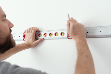 Professional handyman making measurement using a bubble level, home improvement concept