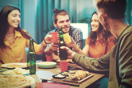 Happy friends spending time together, they are eating and toastingの写真素材