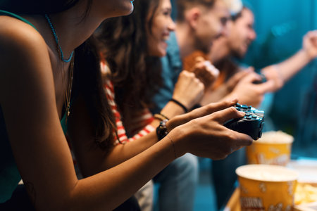Cheerful group of friends playing video games together at home, leisure and entertainment conceptの写真素材
