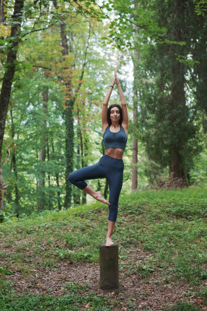 Woman doing a yoga pose in the forest, balance and meditation conceptの写真素材