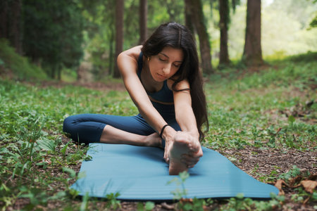 Young woman working out outdoors, she is stretching her legsの写真素材