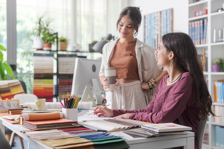 Young female interior designers and architects in the office, they are working together on a project and checking a house planの写真素材