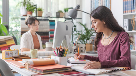 Professional interior designers working in the office, a woman is writing notes on her notebookの写真素材