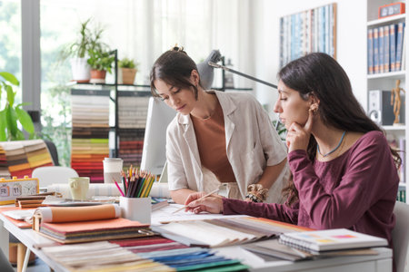 Young female interior designers and architects in the office, they are working together on a project and checking a house planの写真素材