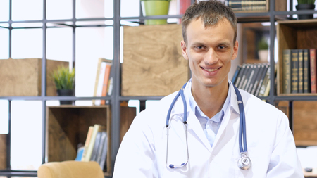 portrait of Young doctor smiling at camera in an office at the hospitalの写真素材