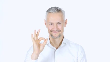 Ok Sign By Grey Haired Middle Aged Businessman , White Backgroundの写真素材