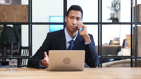 Black Businessman Attending Phone Callの写真素材