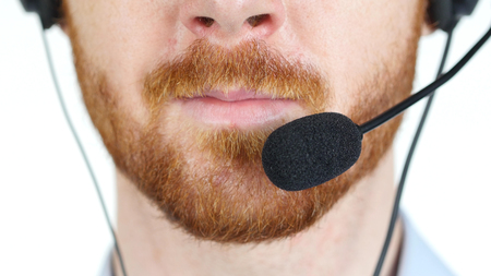 Close-up of business man talking on headset in a call centerの写真素材
