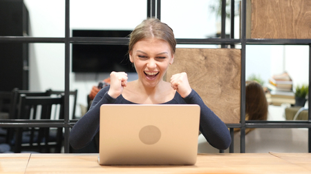 Excitement of Success by Girl working on Laptop, Front Viewの写真素材
