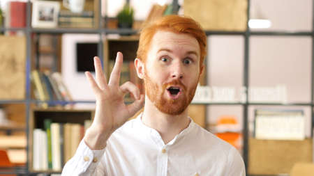 Young man showing sign of Okay, Satisfaction with his Hand Gestureの写真素材