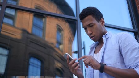 Busy Using Smartphone, Standing Young Black Male Designerの写真素材