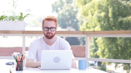 Upset Man after Failure of Project, Loss, Sitting in Outdoor Office, Red Hairsの写真素材