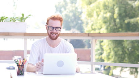 Online Video Communication, Chat by Man Sitting in Outdoor Office, Red Hairsの写真素材