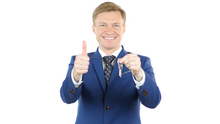 Smiling businessman giving keys of House, Office, Thumbs Upの写真素材
