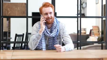 Man Talking on Smartphone, Sitting in Officeの写真素材