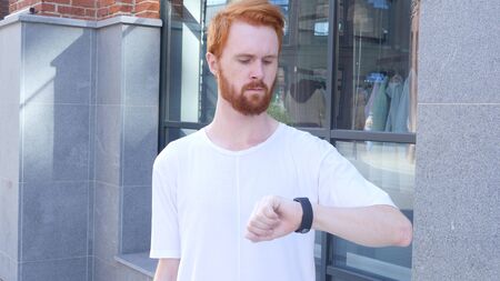 Standing Man Waiting and Watching Time on Wrist Watch, Outdoorの写真素材