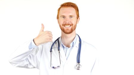Portrait of a doctor showing  thumbs up , white backgroundの写真素材