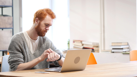 Man Using Smartwatch at Work in Officeの写真素材