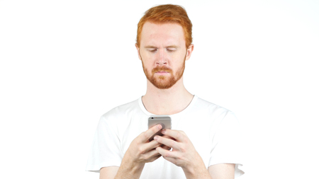 Red Hair man using mobile smart phone, Typing Message on White Backgroundの写真素材
