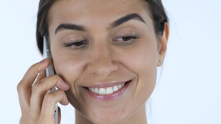 Close up of Girl Talking on Phone, White Background in Studioの写真素材