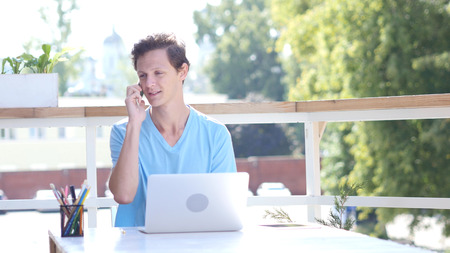 Happy Man Talking on Phone, Sitting at Work, Outdoorの写真素材